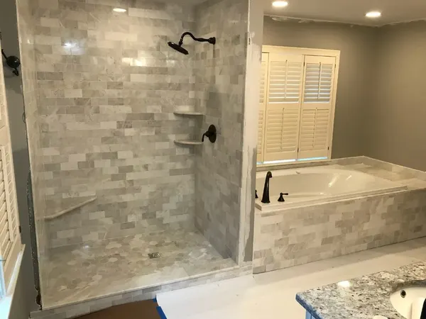 Master Bath Remodel — Subway marble shower walls, hexagonal shower floor, built-in bench, and a fully tiled tub surround.